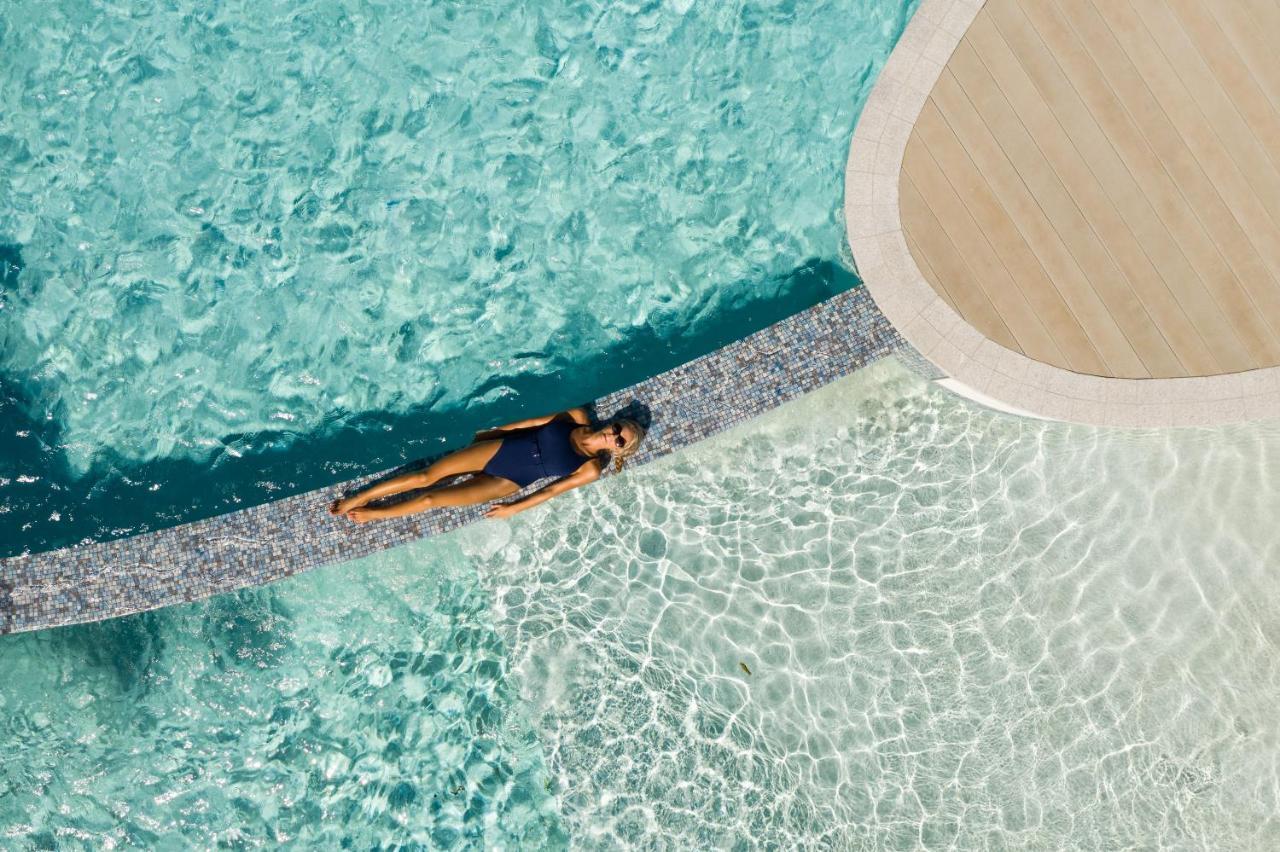 Crystalbrook Riley Hotell Cairns Eksteriør bilde Aerial view of a woman sunbathing in a swimming pool